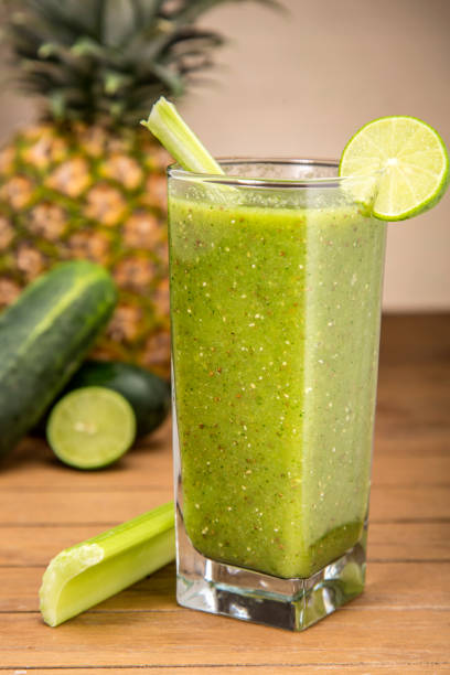 istock Detoxifying green juice with vegetables on wooden board 1305904528