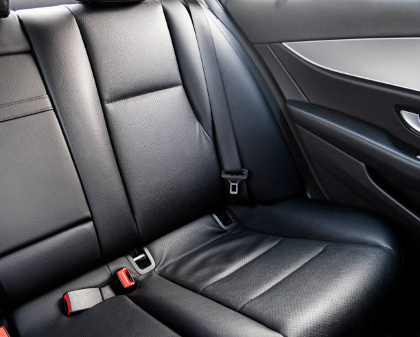 istock Back passenger black leather seats in modern luxury car. Black perforated leather with stitching. Car inside. Leather comfortable red seats. Car interior details 1305906213