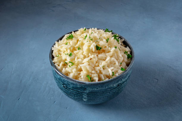istock Rice in a bowl on a dark blue background 1305907830