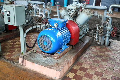 GRODNO, BELARUS - MAY 2020: Interior element of chemical enterprise ammonia reciprocating compressor with cylinders and electric motor with control panel with control devices and alarm systems.