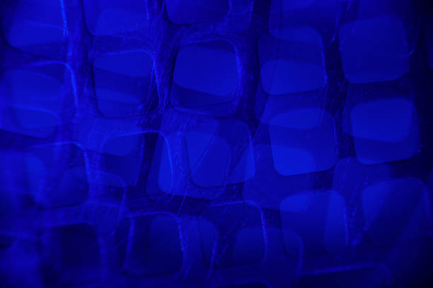 Modern, abstract pattern of worn metal grate lit with blue light.
