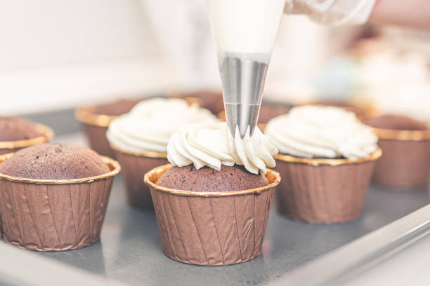 istock covering the cupcakes with vanilla cream 1305908046