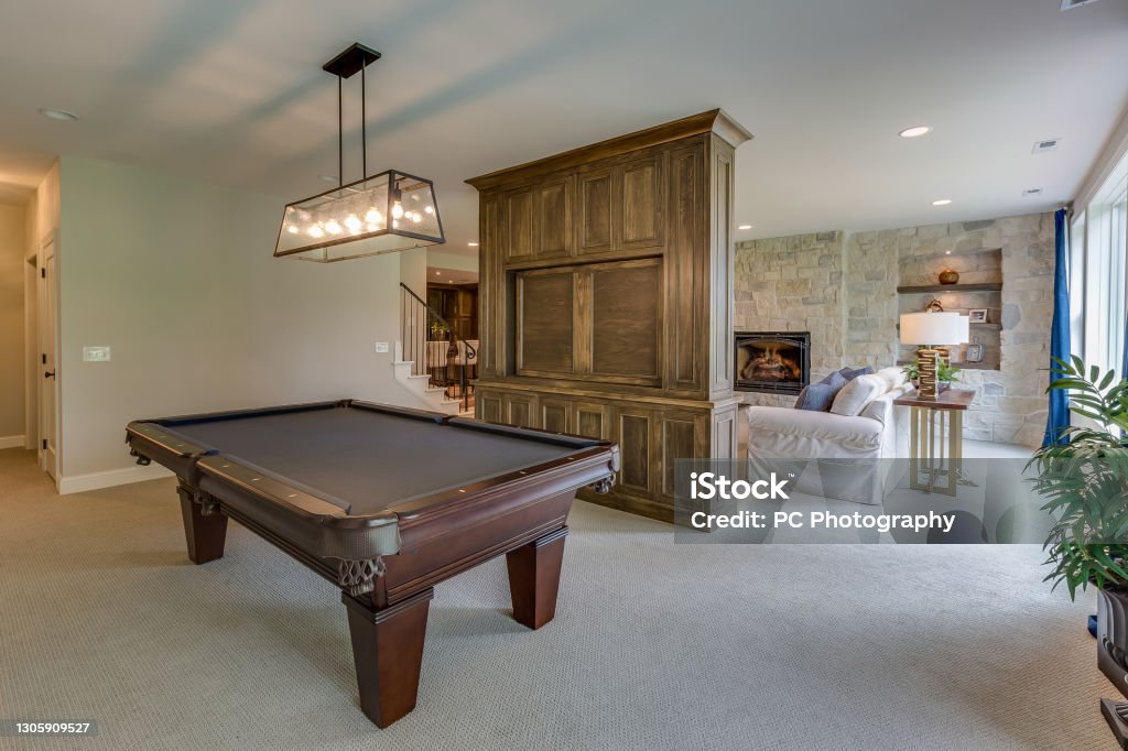 Game room in basement of new home Custom built home with plenty of space for entertaining and enjoying games with company Basement Stock Photo