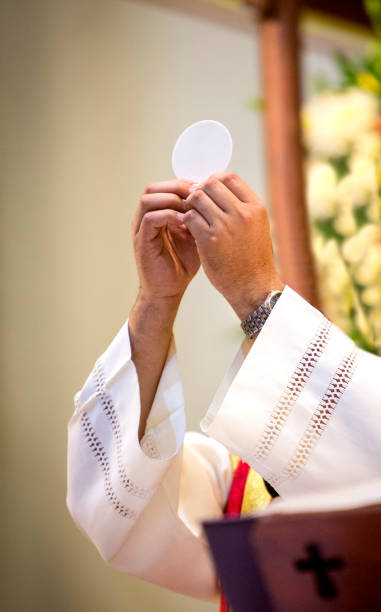 sacerdote consagrando ostia - consecrated fotografías e imágenes de stock