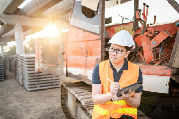 азиатский рабочий с помощью цифрового планшета на строительной площадке - digital tablet construction truck manual worker стоковые фото и изображения