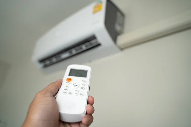 istock Air conditioner inside top the room man operating remote controller open air conditioner energy savings 1305912337