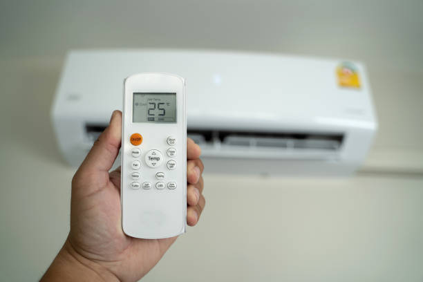 istock Air conditioner inside top the room man operating remote controller open air conditioner energy savings 1305912344