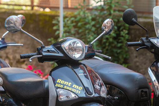 Motorcycles for Hire in Menaggio, Italy, with the Piaggio logo visible as well as the hiring number