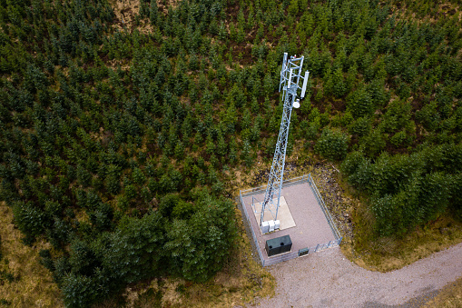 The view from a drone of a telecommunications mast in an area of forest in Dumfries and Galloway south west Scotland