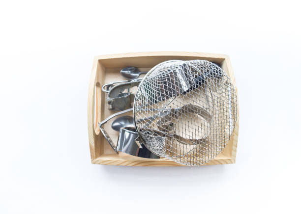 Montessori material in a wooden tray on a white background. Natural metal toys for a child sensory development. Touch hands.