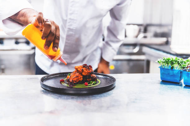 Professional Chef Platting Grilled Chicken Tikka in a Gourmet Kitchen