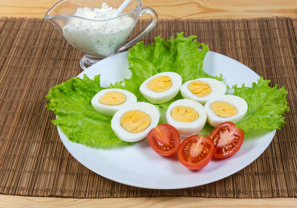 istock Halves of boiled chicken eggs laid out on lettuce, tomatoes 1305920058