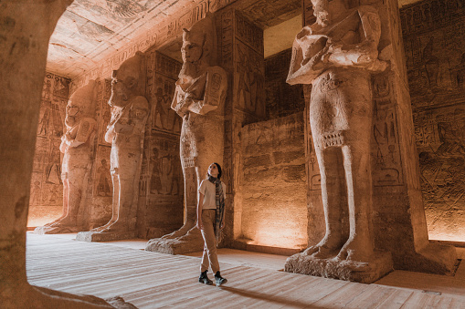 Young Caucasian woman walking inside  Abu Simbel temples