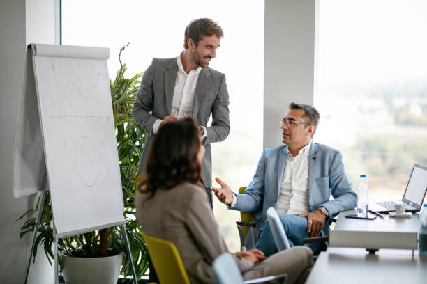 istock Financial advisor discussing graphs drawn on flipchart with manager 1305922498