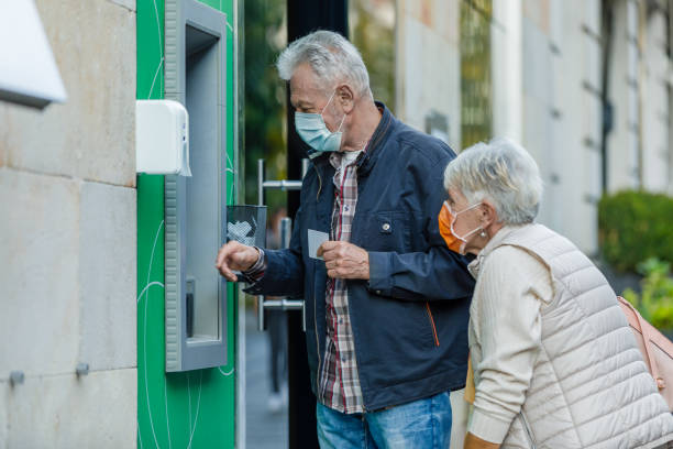 istock Senior Couple is Using ATM During a Pandemic Time. 1305923224