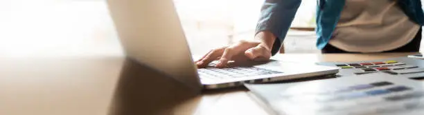 Photo of Creative Freelance Designer Hand working and typing on Laptop in the office. Banner and Panoramic web with copy space.