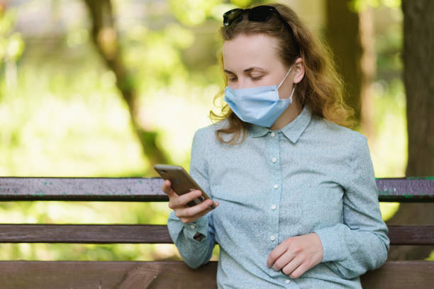 istock A girl is checking her phone on a sunny summer background. 1305924291