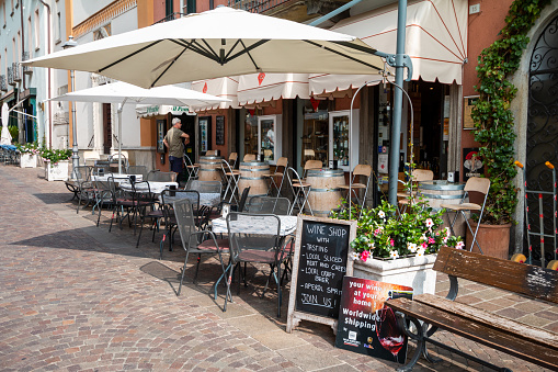 Sidewalk Cafe on Via Calvi in Menaggio, Italy, with people visible in the background
