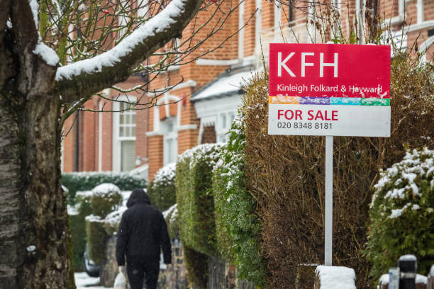 런던 부동산 중개인이 전시된 판매 표지판과 보행자를 배경으로 걷고 있습니다. - row house house uk real estate sign 뉴스 사진 이미지