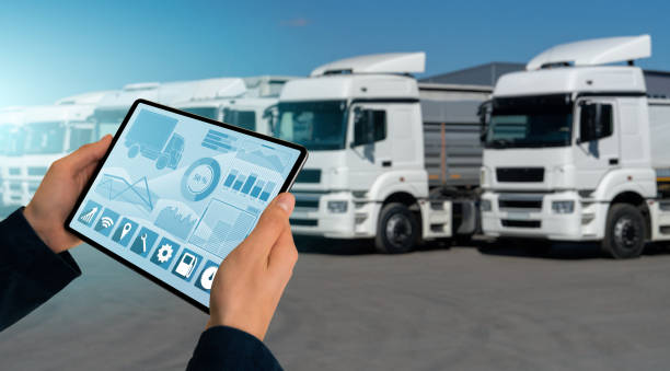 Fleet management Manager with a digital tablet on the background of trucks. Fleet management car hauling stock pictures, royalty-free photos & images