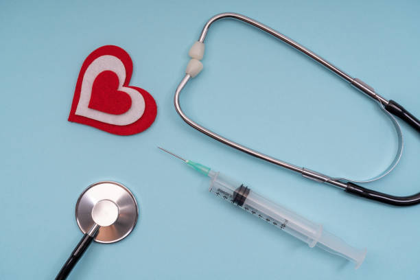 istock Medical tools stethoscope, syringes with a heart on a blue background. 1305927398