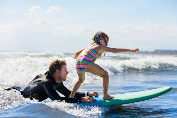 istock Young surfer learn to ride on surfboard with surf instructor 1305928325