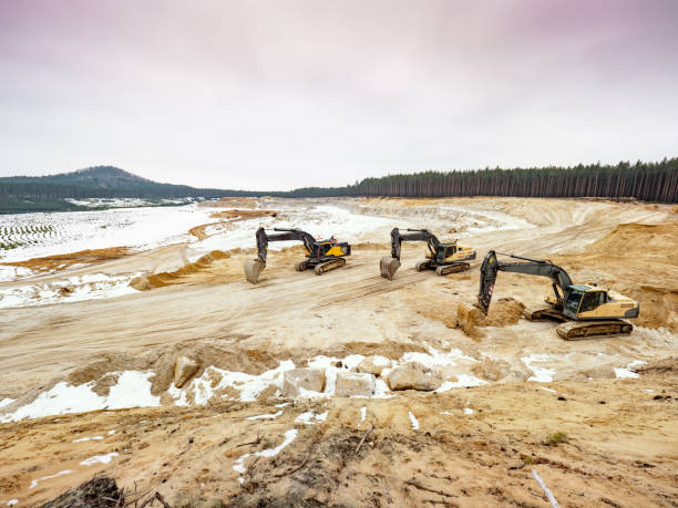 istock Three yellow  excavators in a quarry for quarrying with snow. 1305928477