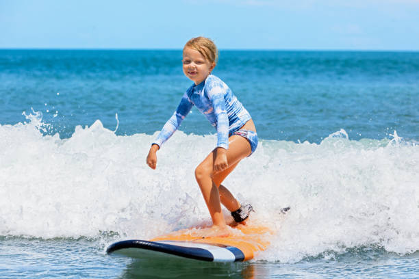 istock Young surfer learn to ride on surfboard on sea waves 1305928513
