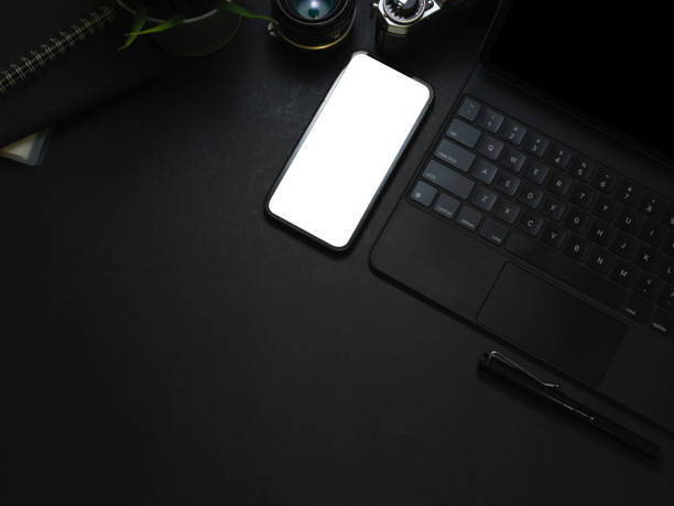 istock Dark workspace with smartphone, keyboard, camera and copy space on the table 1305928581