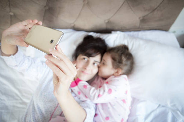 istock Young family taking selfie with smartphone in bed 1305930052