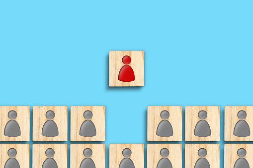 Wooden blocks with gray and red human icons. Teamwork. The concept of leadership, success. Career growth. Business.