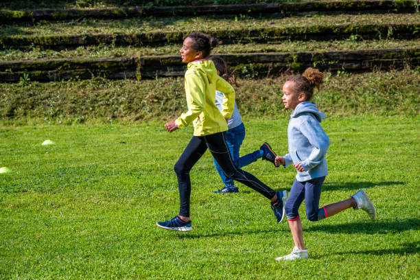 Children running on soccer field stock photo