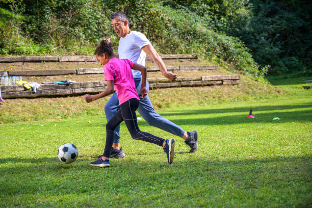 istock Girl practising soccer with coach 1305932402