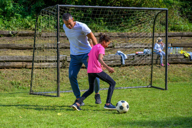 istock Girl practising soccer with coach 1305932429