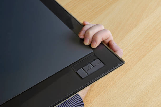 istock Designer's hand holding a graphic tablet from below. 1305932501