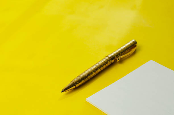 istock White square blank tear-off note paper and pen on yellow background. 1305932544