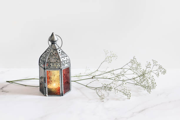 Burning silver vintage Moroccan, Arabic lantern. White gypsophila, babys breath flowers on marble table background. Muslim holiday Ramadan Kareem greeting card, invitation. Empty copy space. Burning silver vintage Moroccan, Arabic lantern. White gypsophila, babys breath flowers on marble table background, muslim holiday Ramadan Kareem greeting card, invitation. Empty copy space. iftar photos stock pictures, royalty-free photos & images