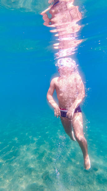 istock Little kid snorkeling on a clear water 1305936334
