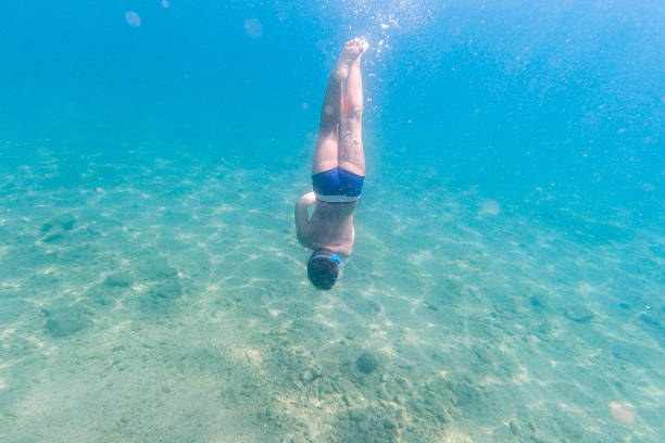 istock Little kid snorkeling on a clear water 1305936335