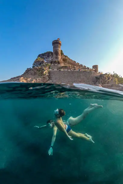 Mother and son snorkeling with a castle in the background