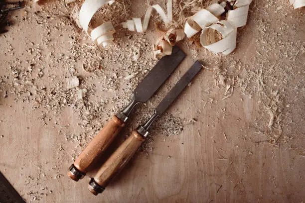 Carpenter's chisel, woodwork tool on the desktop in the workshop close up