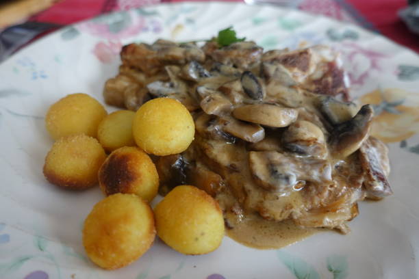 istock Veal chop cooked with cream and button mushrooms served with hazelnut-shaped potatoes 1305937646