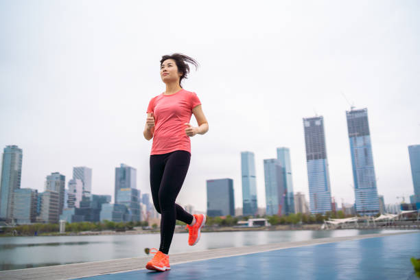 istock Asian woman jogging in a park 1305937723