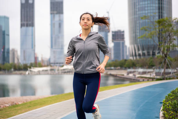 istock Asian woman jogging in a park 1305937769