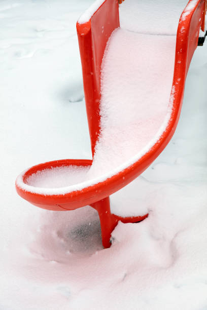 istock Plastic slide covered with snow in the park 1305937781