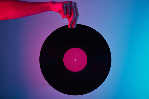 istock Hand hold retro vinyl disc with neon background 1305941699