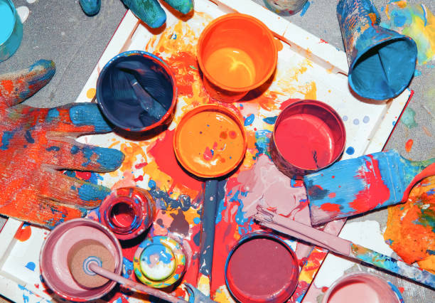 istock ulticolored paints mixed in different jars and cups, painter's tool 1305941979