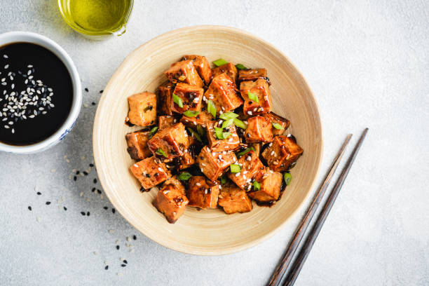 Stir fried marinated tofu Stir fried marinated tofu with sesame seeds, soy sauce and scallions in a bowl, top view tofu stock pictures, royalty-free photos & images