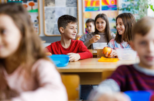 istock Happy children eating in classroom 1305947881