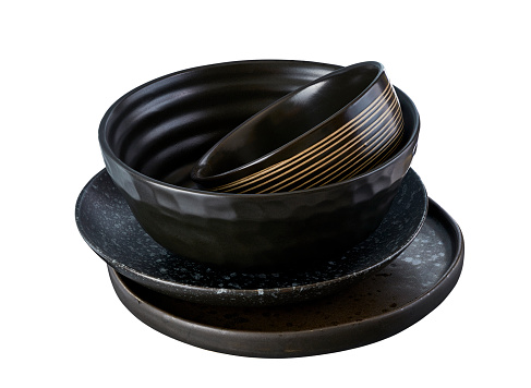 Stacked ceramic plates and bowls, Empty black ceramics plates isolated on white background with clipping path, Side view